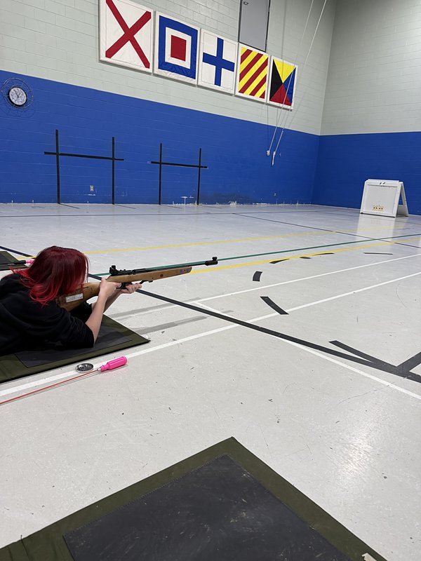 A cadet aiming a target rifle on the range mat